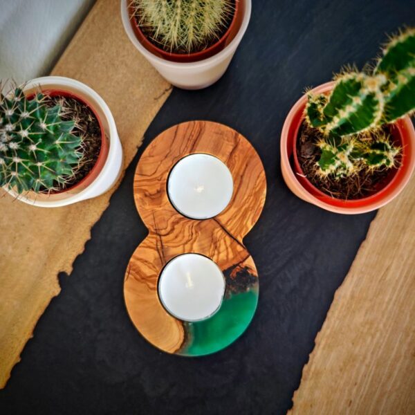 Green epoxy tealight holder on a black walnut desk with a cactus in the background, holding two tealights